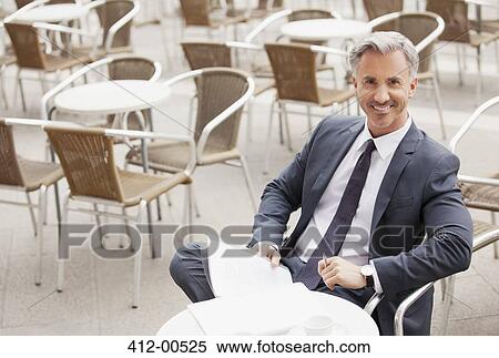 Portrait of smiling businessman with paperwork at sidewalk cafe View Large Photo Image Stock Photography - Portrait of smiling businessman with paperwork at sidewalk cafe. Fotosearch