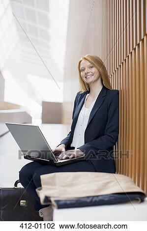 Stock Image - Portrait of smiling businesswoman using laptop. Fotosearch