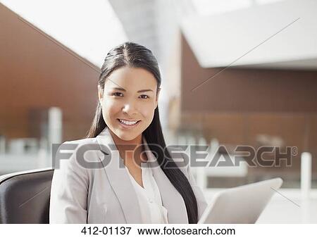 Portrait of smiling businesswoman using digital tablet in office View Large Photo Image Stock Photo - Portrait of smiling businesswoman using digital tablet in office. Fotosearch