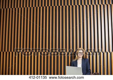 Stock Photography - Portrait of smiling businesswoman using laptop. Fotosearch