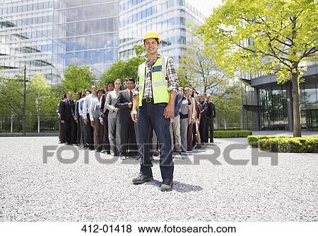 Portrait of smiling construction worker with business people in background View Large Photo Image Stock Photo - Portrait of smiling construction worker with business people in background. Fotosearch