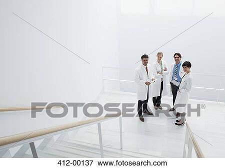 Portrait of smiling doctors on landing of stairs View Large Photo Image Stock Photo - Portrait of smiling doctors on landing of stairs. Fotosearch