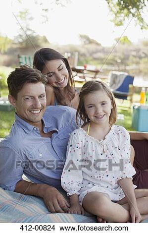Portrait of smiling family picnicking at lakeside View Large Photo Image Picture - Portrait of smiling family picnicking at lakeside. Fotosearch