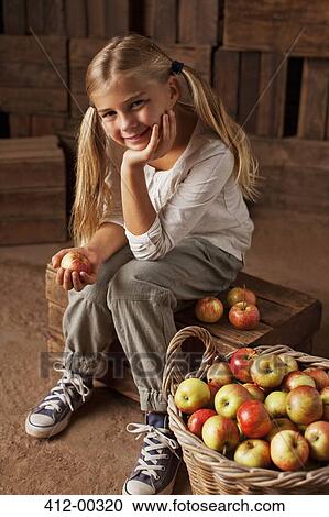 Portrait of smiling girl sitting next to bushel of apples in barn View Large Photo Image Stock Image - Portrait of smiling girl sitting next to bushel of apples in barn. Fotosearch