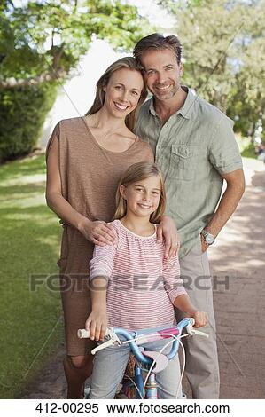 Portrait of smiling parents with daughter on bicycle View Large Photo Image Stock Photography - Portrait of smiling parents with daughter on bicycle. Fotosearch