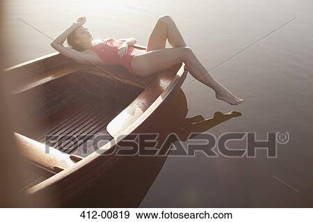 Serene woman sunbathing in boat on lake View Large Photo Image Stock Photo - Serene woman sunbathing in boat on lake. Fotosearch