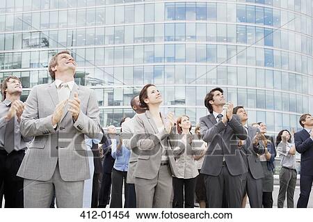 Picture - Smiling business people clapping and looking up. Fotosearch