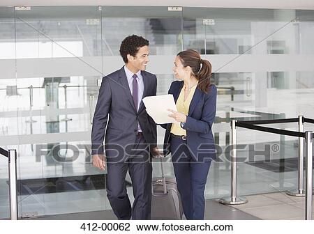 Smiling businessman and businesswoman with file at airport View Large Photo Image Stock Image - Smiling businessman and businesswoman with file at airport. Fotosearch