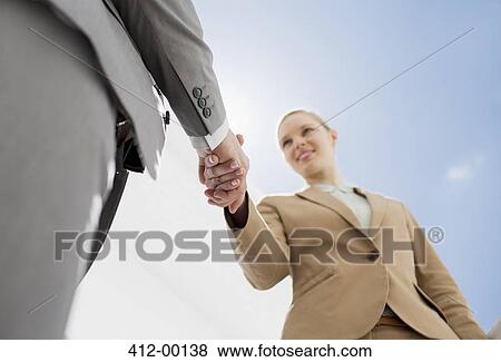 Smiling businesswoman shaking businessman's hand View Large Photo Image Stock Photo - Smiling businesswoman shaking businessman's hand. Fotosearch