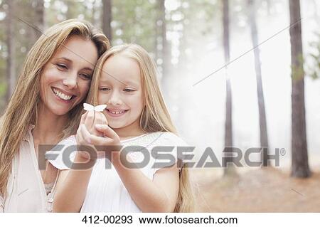 Smiling mother and daughter holding butterfly in woods View Large Photo Image Stock Image - Smiling mother and daughter holding butterfly in woods. Fotosearch