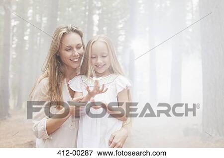 Smiling mother and daughter in sunny woods View Large Photo Image Stock Photo - Smiling mother and daughter in sunny woods. Fotosearch