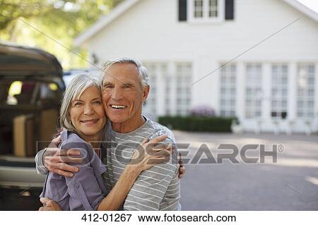 Stock Photo - Smiling older couple hugging outdoors. Fotosearch