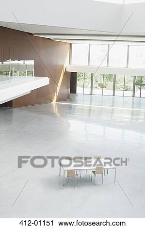 Stock Image - Table and chairs in empty office lobby. Fotosearch