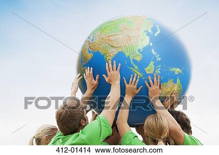 Team in green t-shirts lifting globe overhead View Large Photo Image Picture - Team in green t-shirts lifting globe overhead. Fotosearch