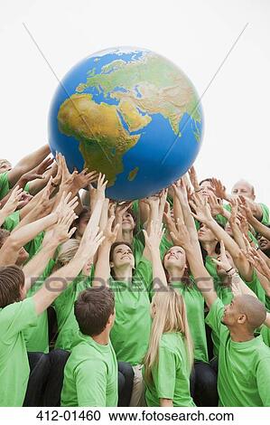 Team in green t-shirts reaching for globe overhead View Large Photo Image Stock Image - Team in green t-shirts reaching for globe overhead. Fotosearch