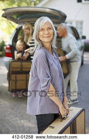 Woman carrying suitcase to trunk View Large Photo Image Stock Photo - Woman carrying suitcase to trunk. Fotosearch