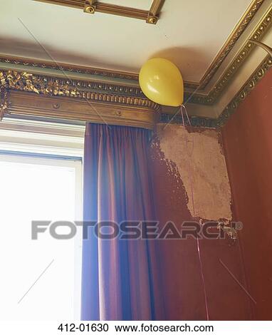 Stock Image - Balloon floating in corner of ornate room. Fotosearch