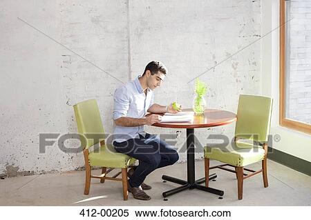 Businessman reading at table in office View Large Photo Image Stock Photography - Businessman reading at table in office. Fotosearch