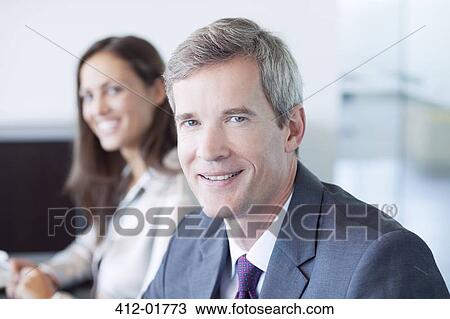 Businessman smiling in meeting View Large Photo Image Stock Image - Businessman smiling in meeting. Fotosearch