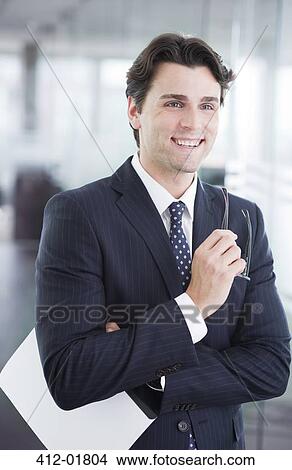 Businessman smiling in office hallway View Large Photo Image Picture - Businessman smiling in office hallway. Fotosearch