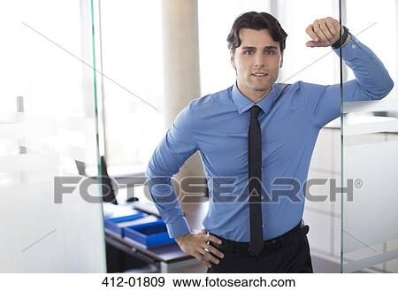 Stock Photo - Businessman standing in office hallway. Fotosearch