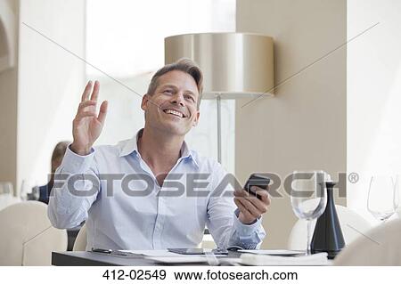 Businessman using cell phone in restaurant View Large Photo Image Stock Photo - Businessman using cell phone in restaurant. Fotosearch