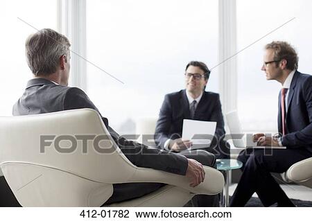 Businessmen talking in office lobby View Large Photo Image Stock Image - Businessmen talking in office lobby. Fotosearch