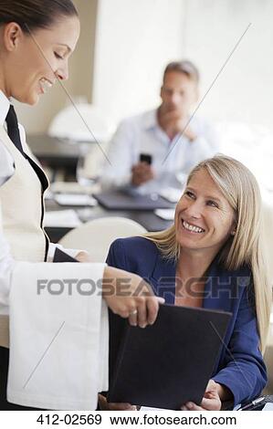 Stock Photo - Businesswoman ordering in restaurant. Fotosearch