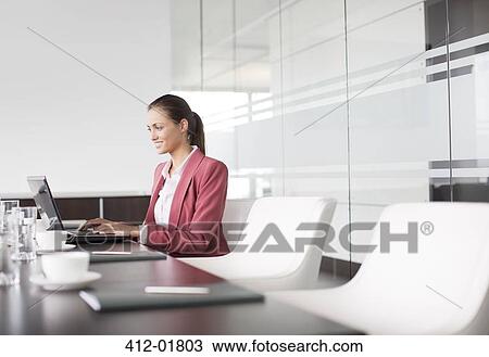 Stock Image - Businesswoman working at meeting table. Fotosearch