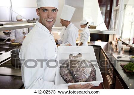 Chef carrying tub of fresh fish in restaurant kitchen View Large Photo Image Stock Image - Chef carrying tub of fresh fish in restaurant kitchen. Fotosearch