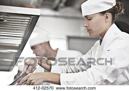Stock Image - Chef cooking in restaurant kitchen. Fotosearch