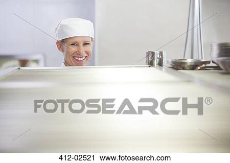Chef smiling in restaurant kitchen View Large Photo Image Stock Image - Chef smiling in restaurant kitchen. Fotosearch
