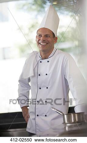 Chef smiling in restaurant kitchen View Large Photo Image Stock Image - Chef smiling in restaurant kitchen. Fotosearch