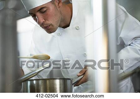 Chef tasting food in restaurant kitchen View Large Photo Image Picture - Chef tasting food in restaurant kitchen. Fotosearch