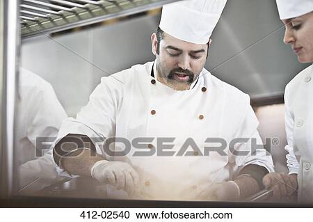 Chefs cooking in restaurant kitchen View Large Photo Image Stock Image - Chefs cooking in restaurant kitchen. Fotosearch