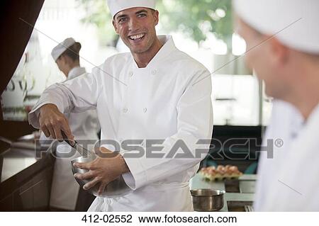 Stock Image - Chefs cooking in restaurant kitchen. Fotosearch