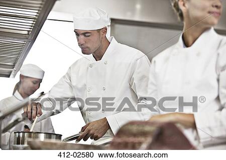 Chefs cooking in restaurant kitchen View Large Photo Image Stock Image - Chefs cooking in restaurant kitchen. Fotosearch