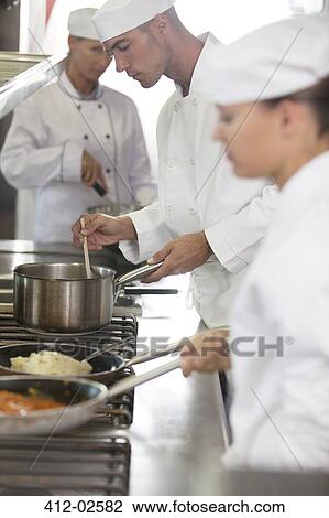 Chefs cooking in restaurant kitchen View Large Photo Image Stock Image - Chefs cooking in restaurant kitchen. Fotosearch