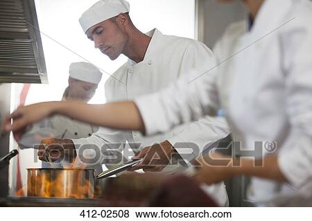 Stock Photo - Chefs cooking in restaurant kitchen. Fotosearch