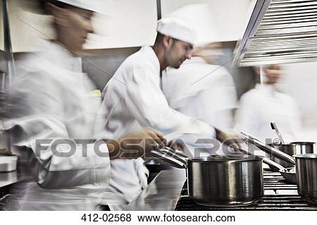 Stock Photo - Chefs cooking in restaurant kitchen. Fotosearch