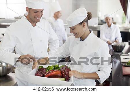 Chefs examining vegetables in restaurant kitchen View Large Photo Image Stock Photograph - Chefs examining vegetables in restaurant kitchen. Fotosearch