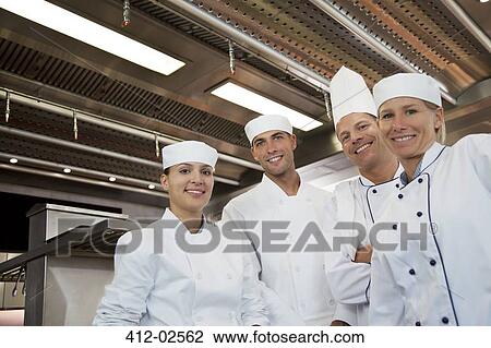 Stock Image - Chefs smiling in restaurant kitchen. Fotosearch