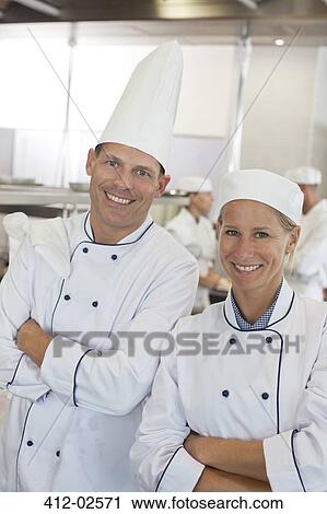Stock Image - Chefs smiling in restaurant kitchen. Fotosearch