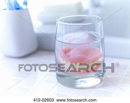 Close up of dentures soaking in glass of water View Large Photo Image Stock Image - Close up of dentures soaking in glass of water. Fotosearch