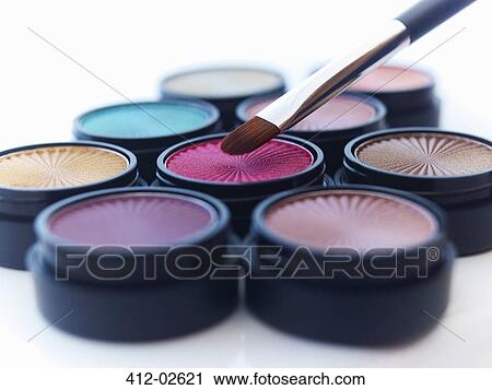 Stock Image - Close up of makeup brush and eyeshadows. Fotosearch