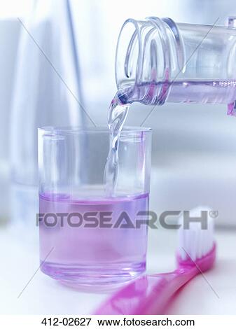 Close up of mouthwash pouring into cup View Large Photo Image Stock Photo - Close up of mouthwash pouring into cup. Fotosearch