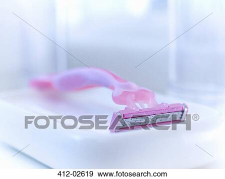 Stock Photo - Close up of pink razor in bathroom. Fotosearch