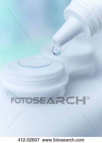 Stock Photo - Close up of saline dropping on contact lens. Fotosearch