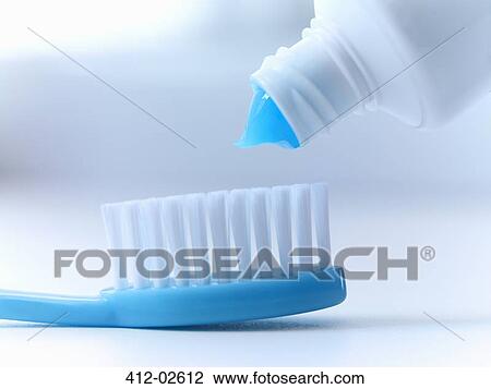 Stock Image - Close up of toothpaste squeezing on toothbrush. Fotosearch