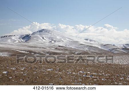 Clouds over hills in snowy landscape View Large Photo Image Stock Photograph - Clouds over hills in snowy landscape. Fotosearch